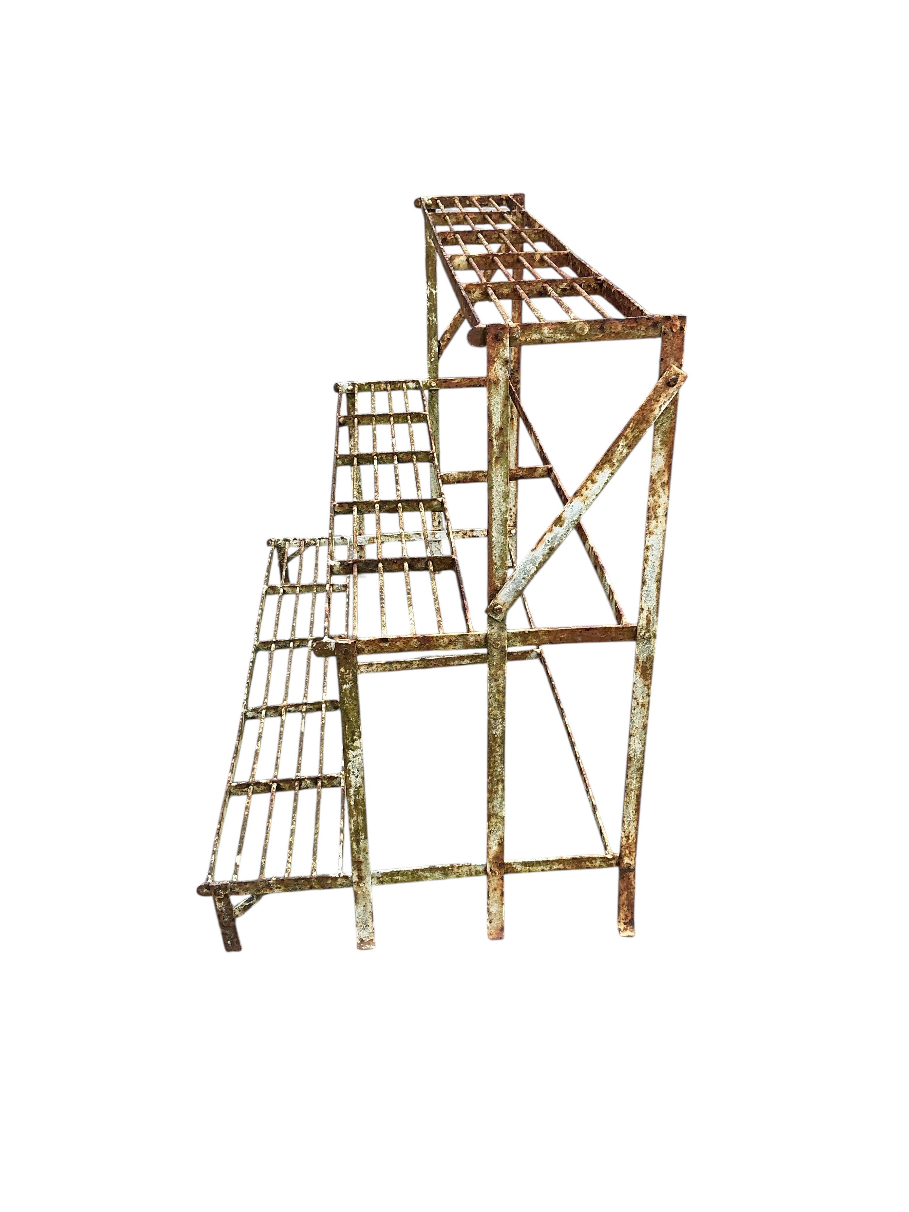 A painted wrought iron three tier pot stand, width 100cm, depth 50cm, height 73cm